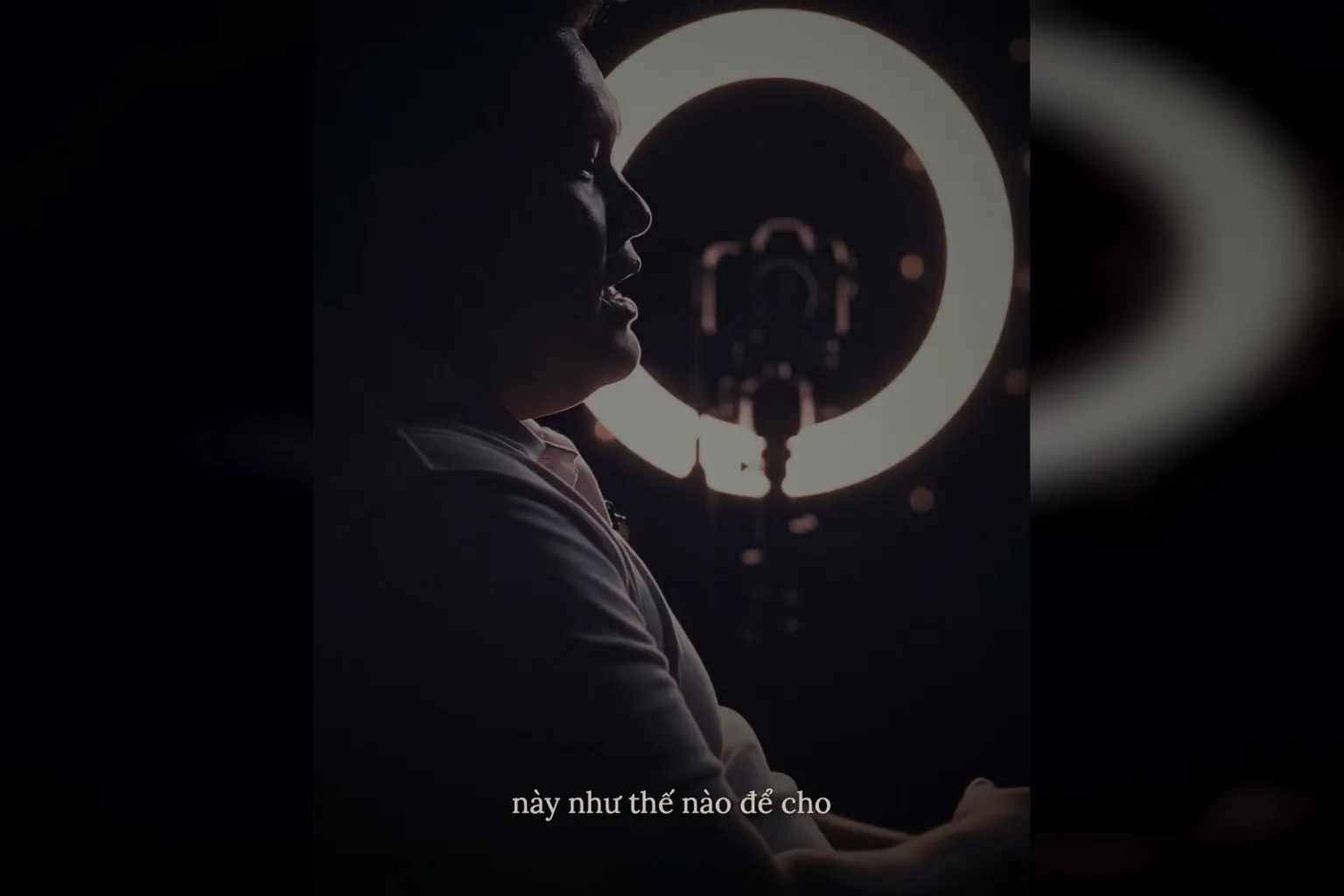 AI edit video tâm sự thế nào: bóng người nói bên đèn vòng trong phòng tối, phụ đề chữ mảnh hiện mờ