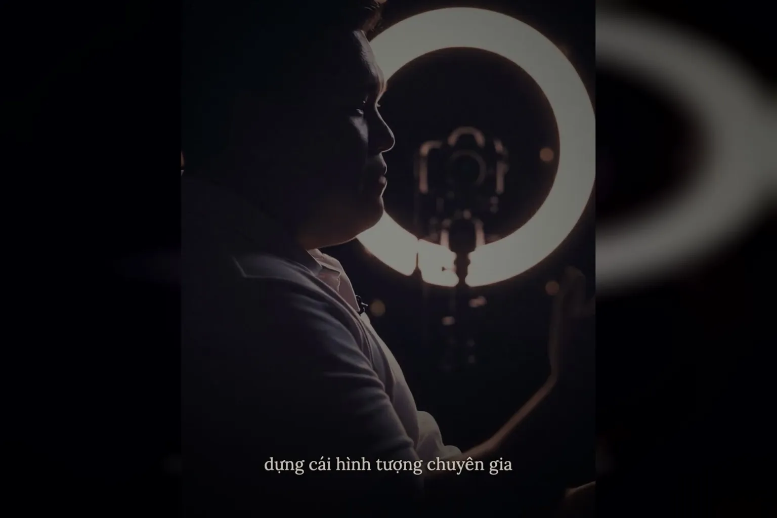 Xây hình tượng chuyên gia bằng video: bóng người nói bên đèn vòng trong phòng tối, phụ đề dựng cái hình tượng chuyên gia